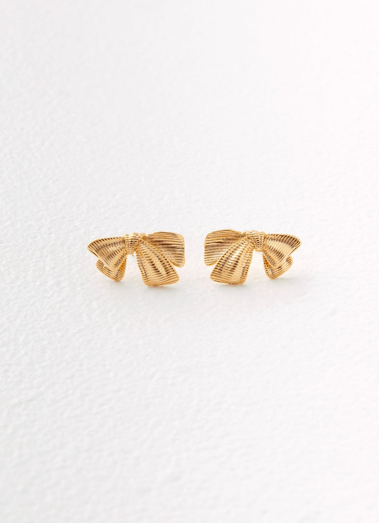 Womens Kiyah Bow Earrings in the colour Gold in front of a light grey background