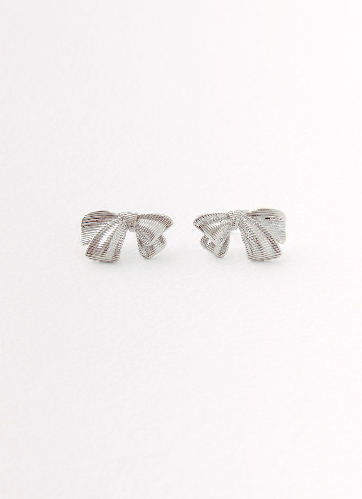 Womens Kiyah Bow Earrings in the colour Silver in front of a light grey background