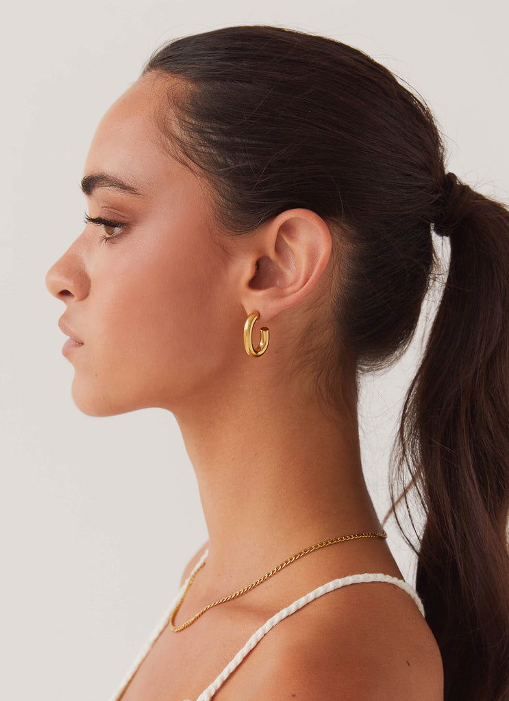 Womens Stardust Hoop Earrings in the colour Gold in front of a light grey background