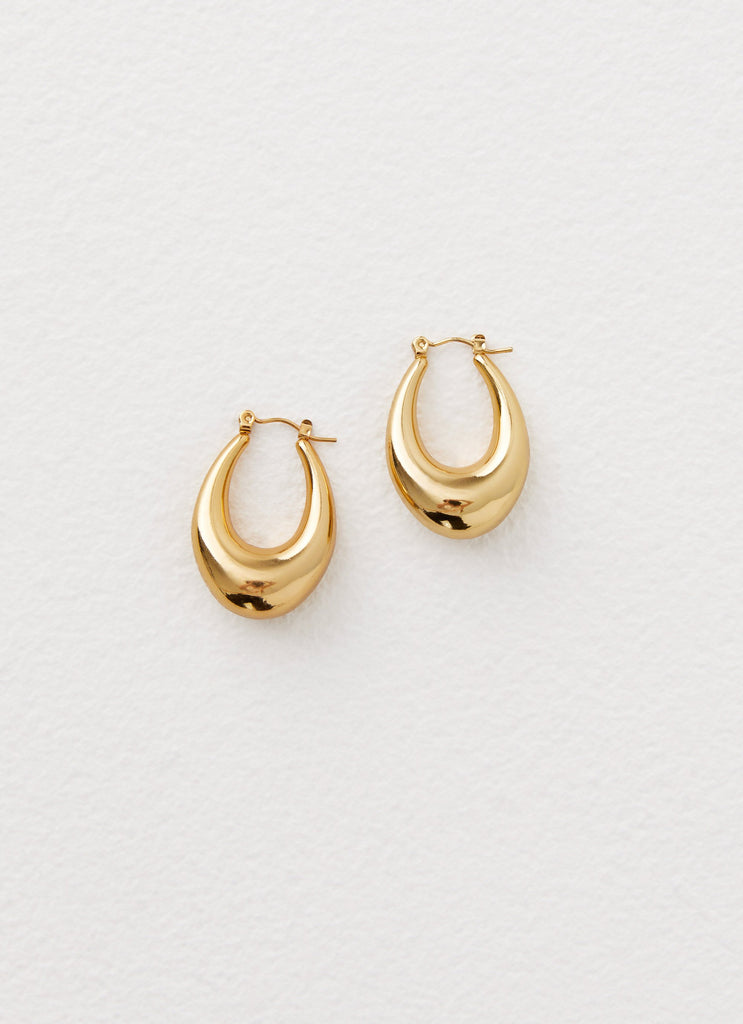 Womens Slow Down Earrings in the colour Gold in front of a light grey background