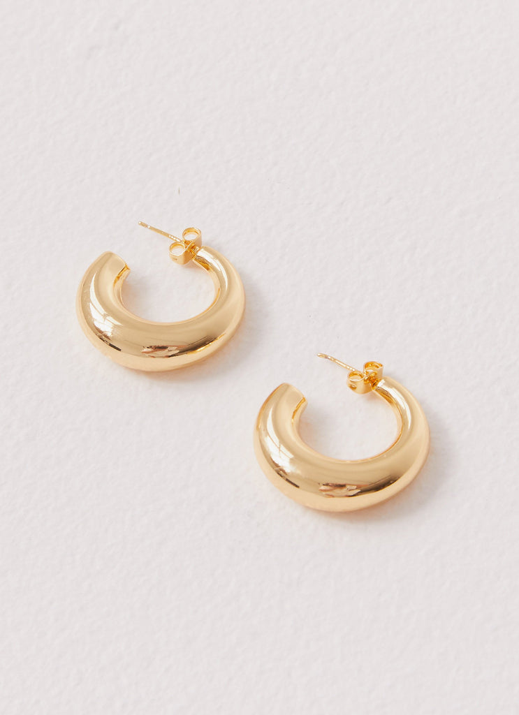 Womens Calisse Hoop Earrings in the colour Gold in front of a light grey background