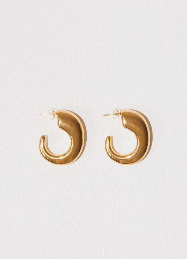 Womens Glow Girl Hoop Earrings in the colour Gold in front of a light grey background